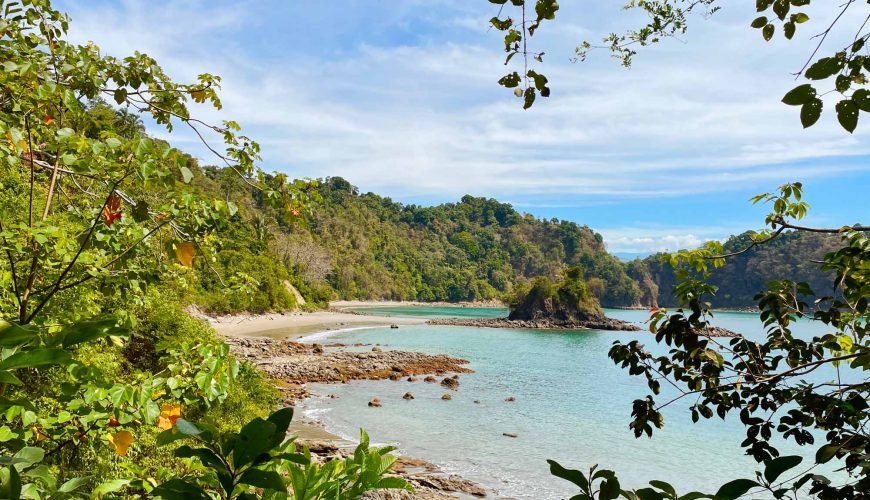 Puerto Escondido beach, rocky shoreline and rainforest in Manuel Antonio National Park