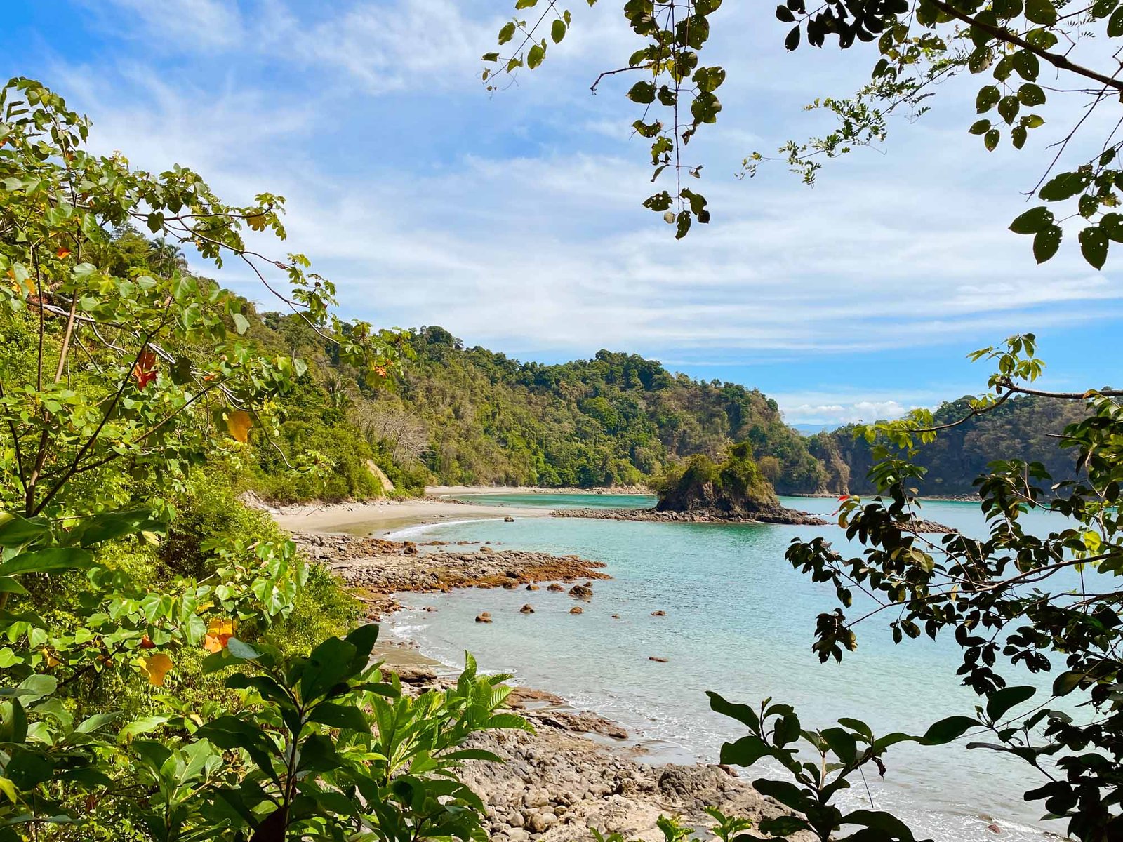 Puerto Escondido beach, rocky shoreline and rainforest in Manuel Antonio National Park